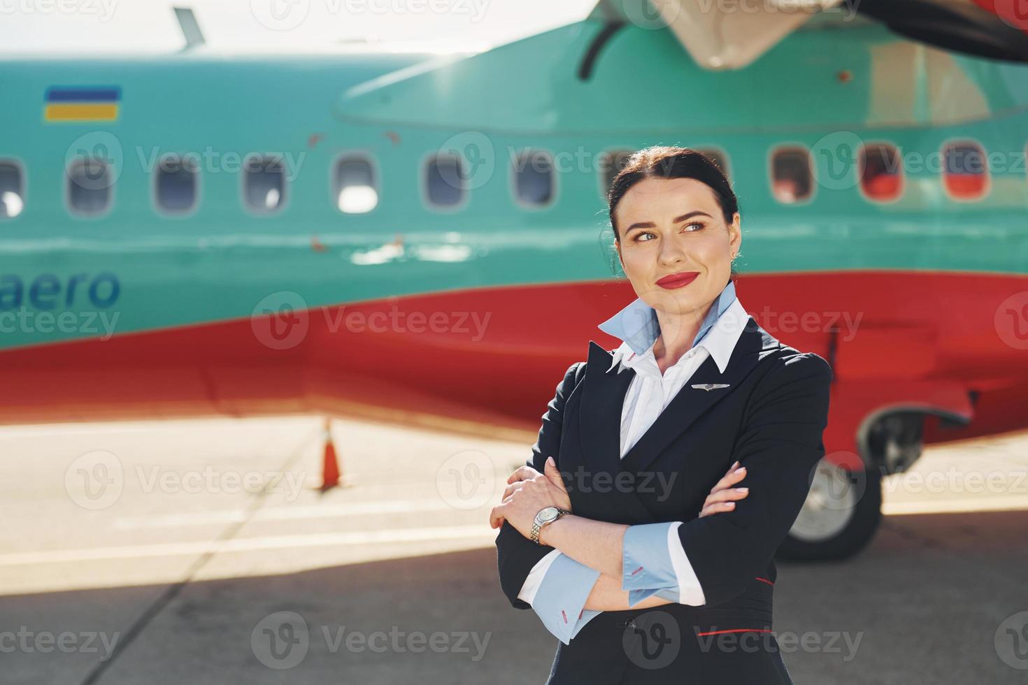 Stewardess. Besatzung von Flughafen- und Flugzeugarbeitern in formeller Kleidung, die zusammen im Freien stehen foto