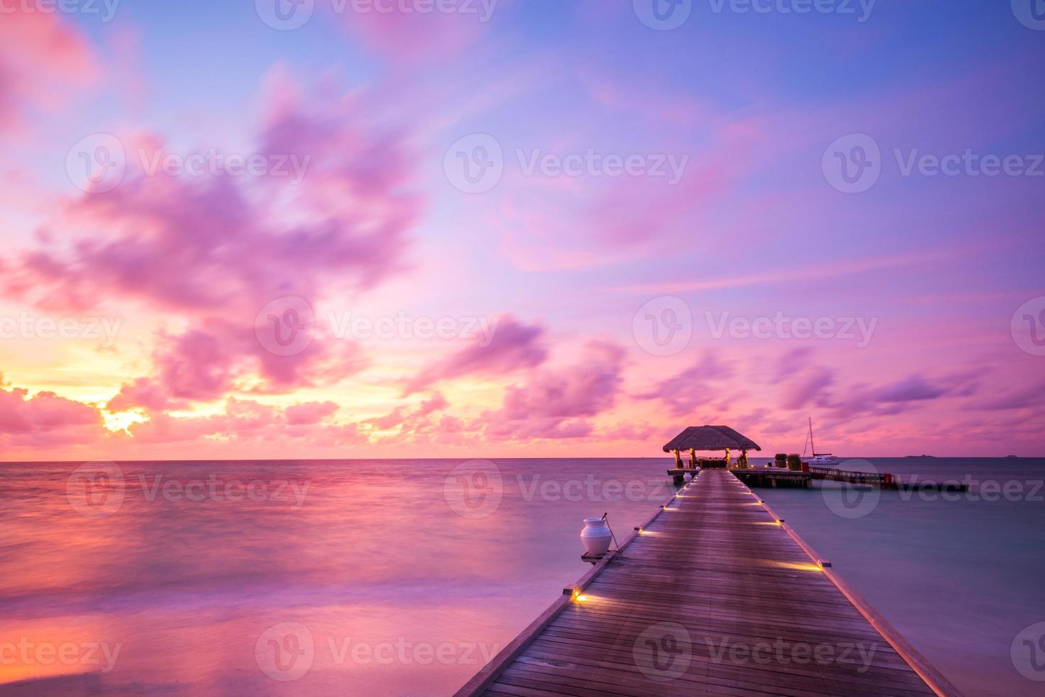 tolle Strandlandschaft. schöne Aussicht auf den Sonnenuntergang auf den Malediven. horizont bunte meer himmel wolken, über wasser villa pier weg. ruhige insellagune, tourismusreisehintergrund. exotischer Urlaub foto