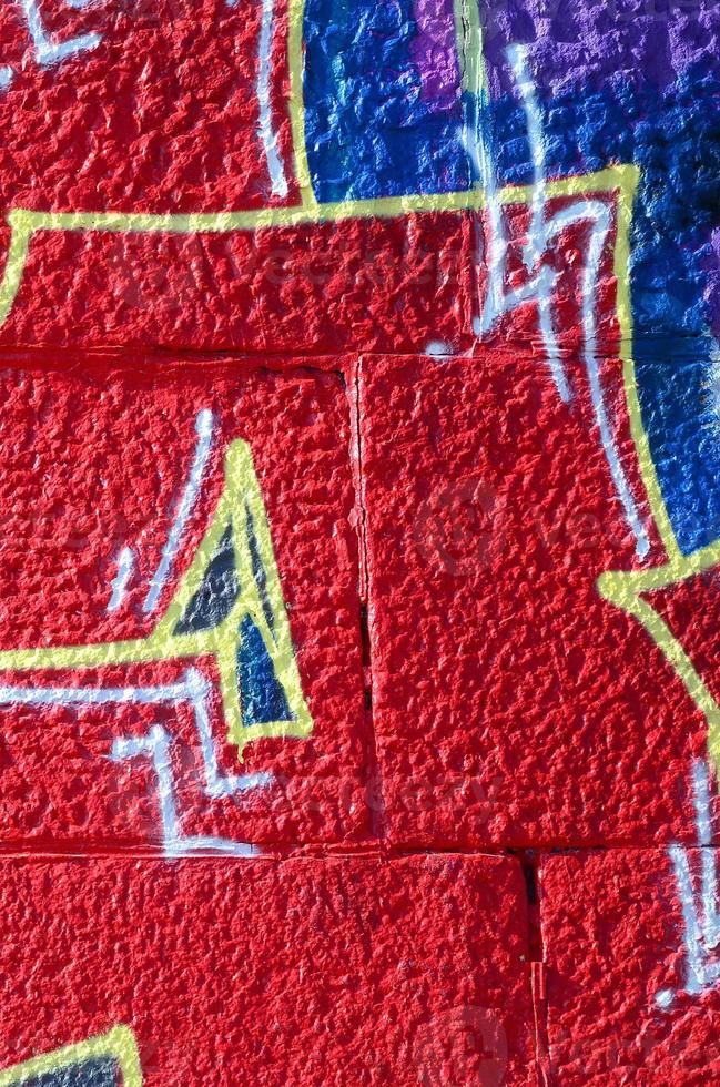 Fragment von Graffiti-Zeichnungen. Die alte Wand ist mit Farbflecken im Stil der Straßenkunstkultur dekoriert. farbige Hintergrundtextur in warmen Tönen foto