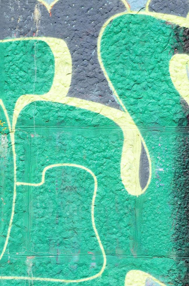 Fragment von Graffiti-Zeichnungen. Die alte Wand ist mit Farbflecken im Stil der Straßenkunstkultur dekoriert. farbige Hintergrundtextur in Grüntönen foto