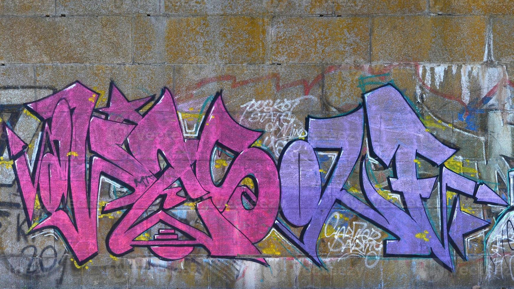 Fragment von Graffiti-Zeichnungen. Die alte Wand ist mit Farbflecken im Stil der Straßenkunstkultur dekoriert. farbige Hintergrundtextur in violetten Tönen foto