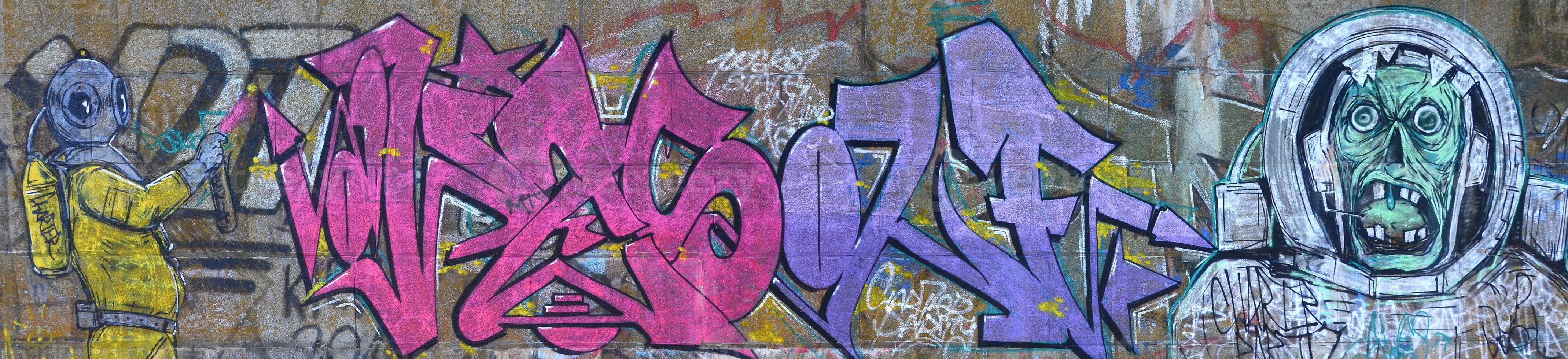 Fragment von Graffiti-Zeichnungen. Die alte Wand ist mit Farbflecken im Stil der Straßenkunstkultur dekoriert. gruseliger Taucher foto