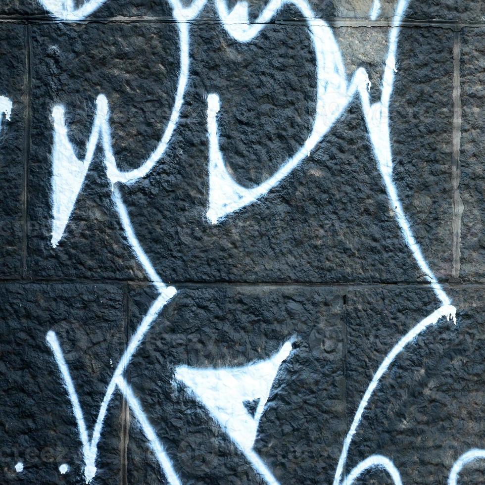 Fragment von Graffiti-Zeichnungen. Die alte Wand ist mit Farbflecken im Stil der Straßenkunstkultur dekoriert. farbige Hintergrundtextur foto