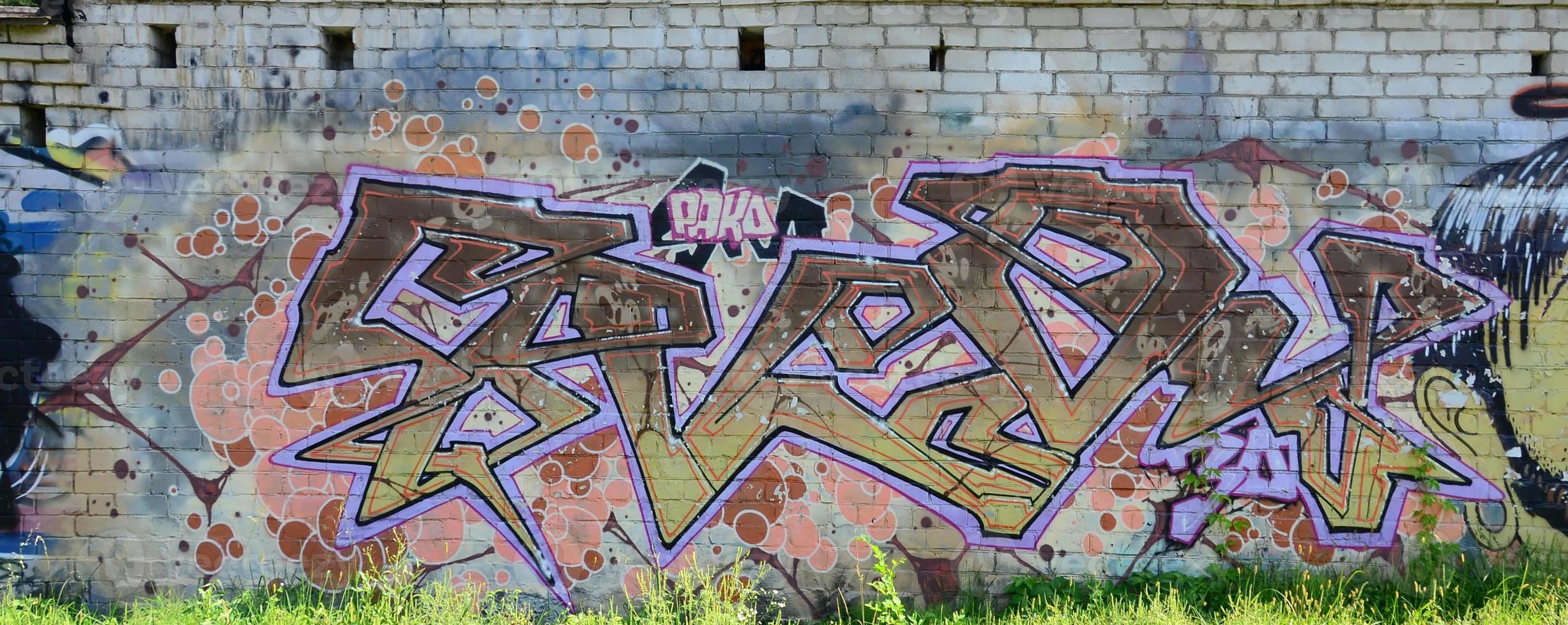 Fragment von Graffiti-Zeichnungen. Die alte Wand ist mit Farbflecken im Stil der Straßenkunstkultur dekoriert. farbige Hintergrundtextur in warmen Tönen foto