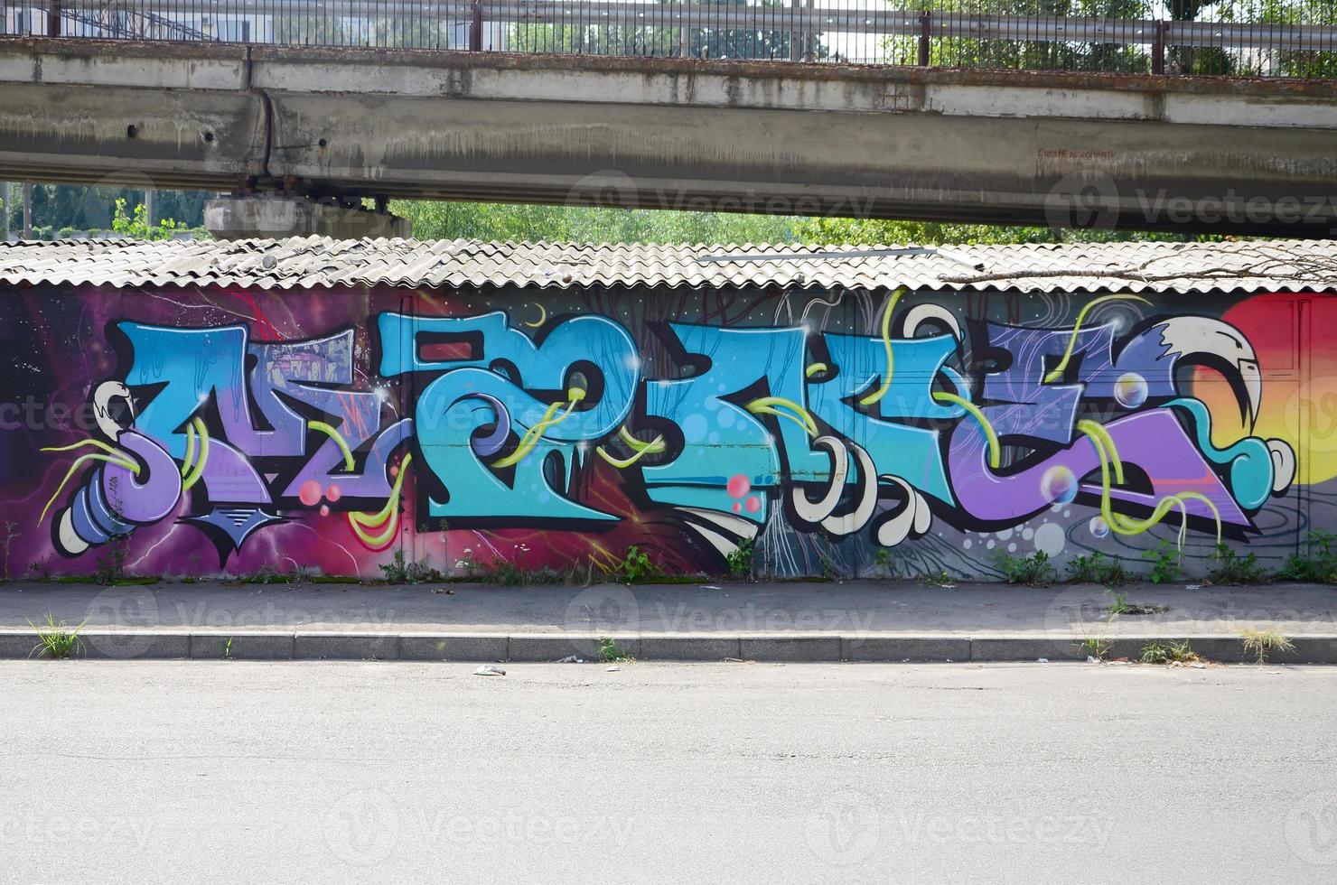 Fragment von Graffiti-Zeichnungen. Die alte Wand ist mit Farbflecken im Stil der Straßenkunstkultur dekoriert. farbige Hintergrundtextur in kalten Tönen foto