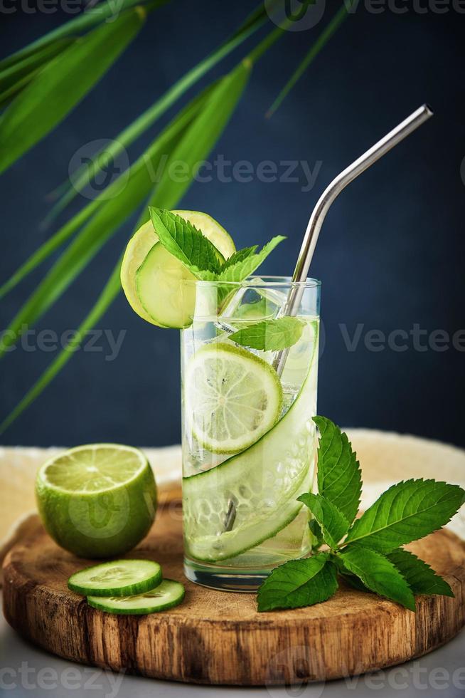 Glas Wasser mit Kiwi, Limette und Minze auf dunklem Hintergrund foto