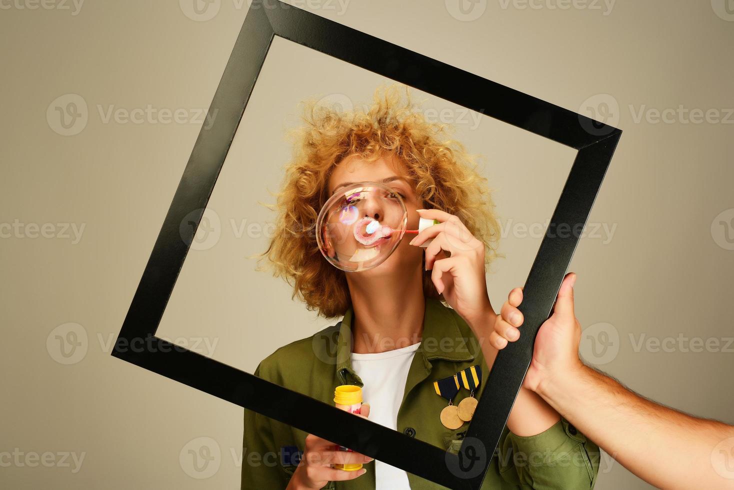 Frau im Bilderrahmen bläst Seifenblasen foto