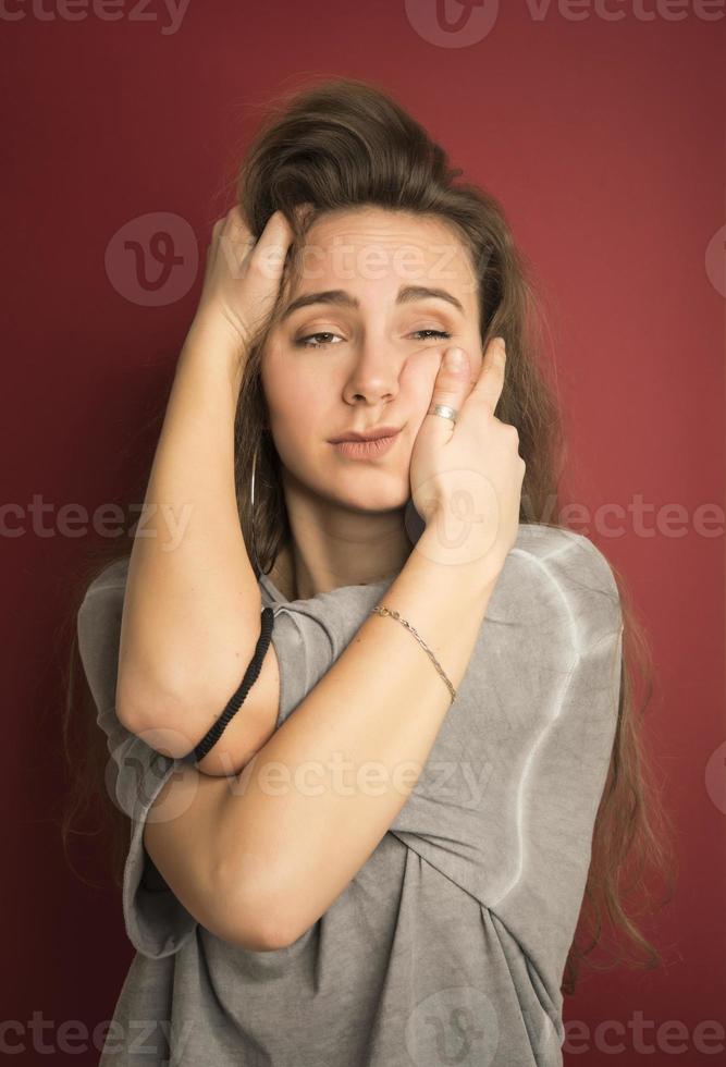 Porträt eines emotional positiven europäischen Teenager-Mädchens, das ihr helles Haar in einem Brötchen trägt und vor Erstaunen oder Erstaunen schreit und die Hände auf dem Gesicht hält foto