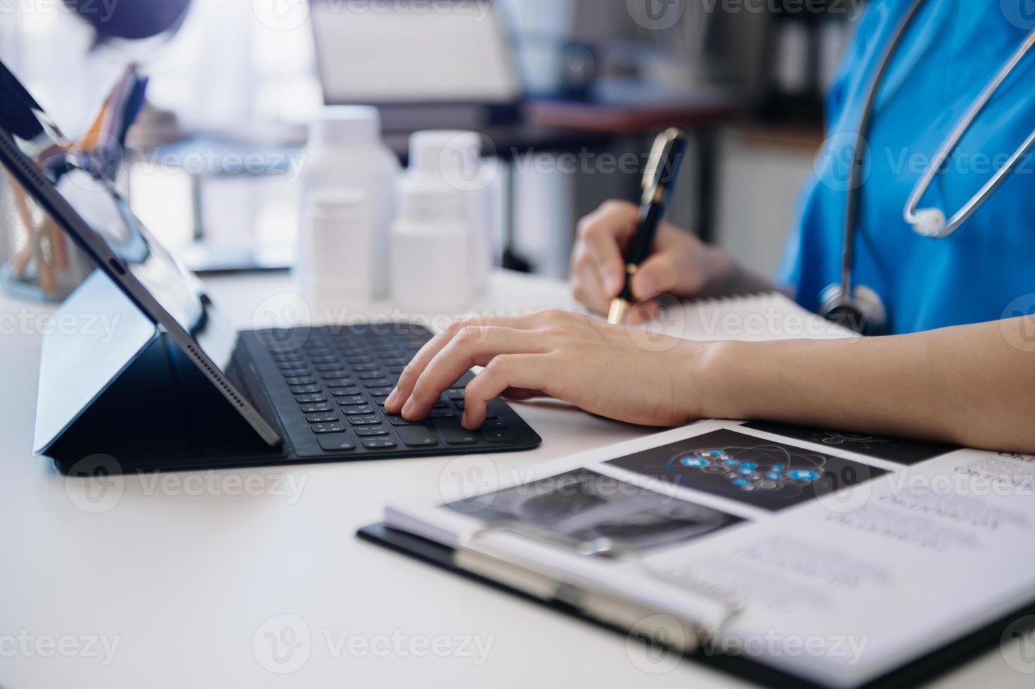 medizintechnisches Konzept. arzt, der mit handy und stethoskop im büro arbeitet foto