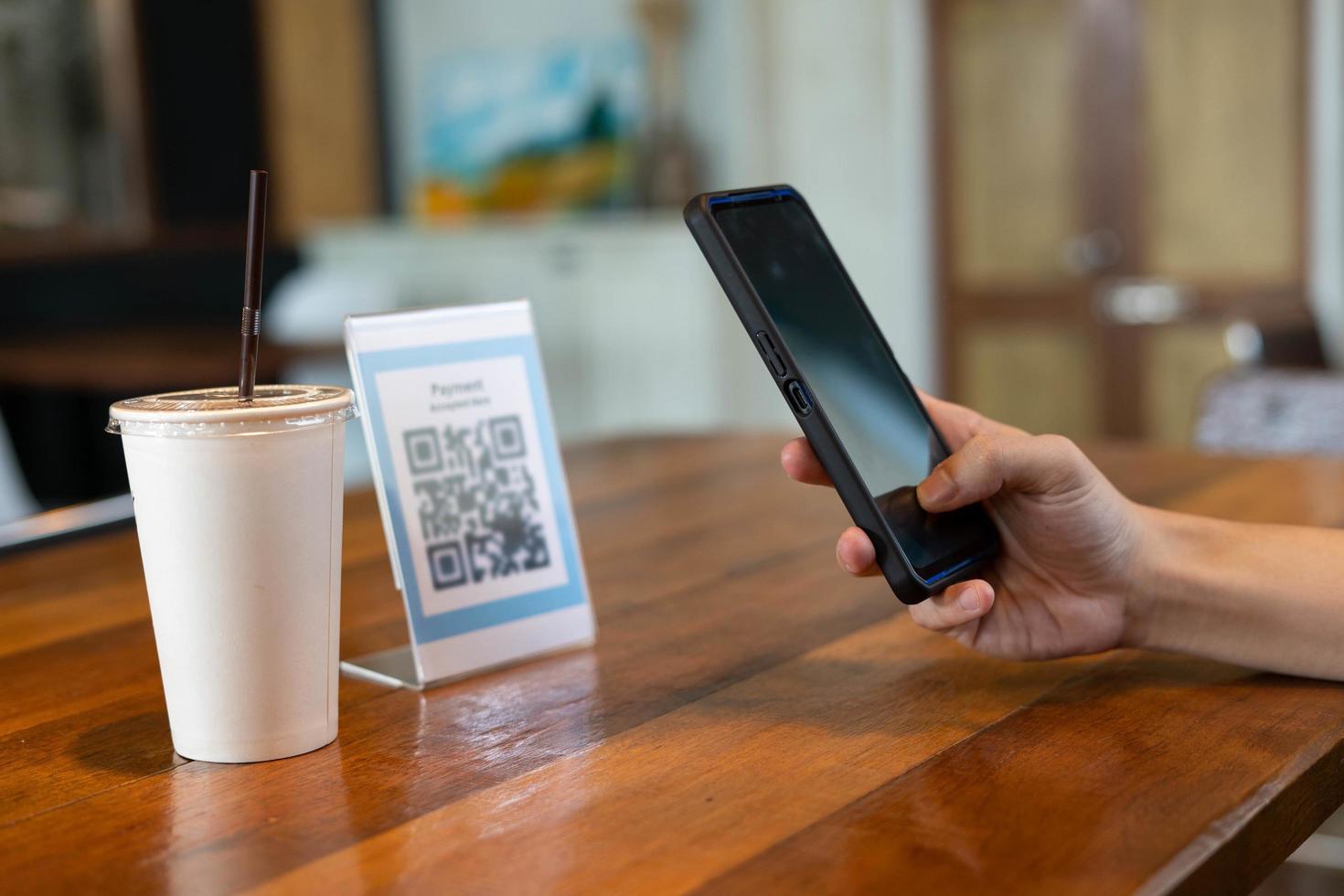 mann verwendet smartphone, um qr-code zu scannen, um im caférestaurant mit einer digitalen zahlung ohne bargeld zu bezahlen. Menü wählen und bestellen Rabatt kumulieren. E-Geldbörse, Technologie, online bezahlen, Kreditkarte, Bank-App foto