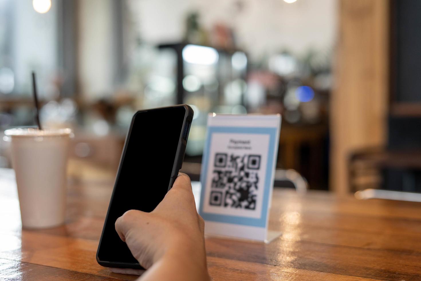 mann verwendet smartphone, um qr-code zu scannen, um im caférestaurant mit einer digitalen zahlung ohne bargeld zu bezahlen. Menü wählen und bestellen Rabatt kumulieren. E-Geldbörse, Technologie, online bezahlen, Kreditkarte, Bank-App foto