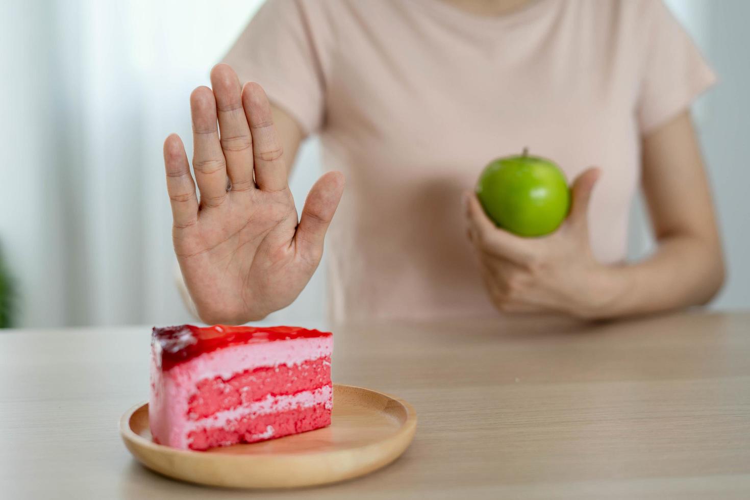 Frauen mit schlankem Körper wählen gesunde Lebensmittel und Junk Food, Frauen wählen grünen Apfel für die Ernährung. gutes gesundes essen. Gewicht verlieren, Gleichgewicht halten, kontrollieren, Fett reduzieren, wenig Kalorien, Routinen, Bewegung. foto