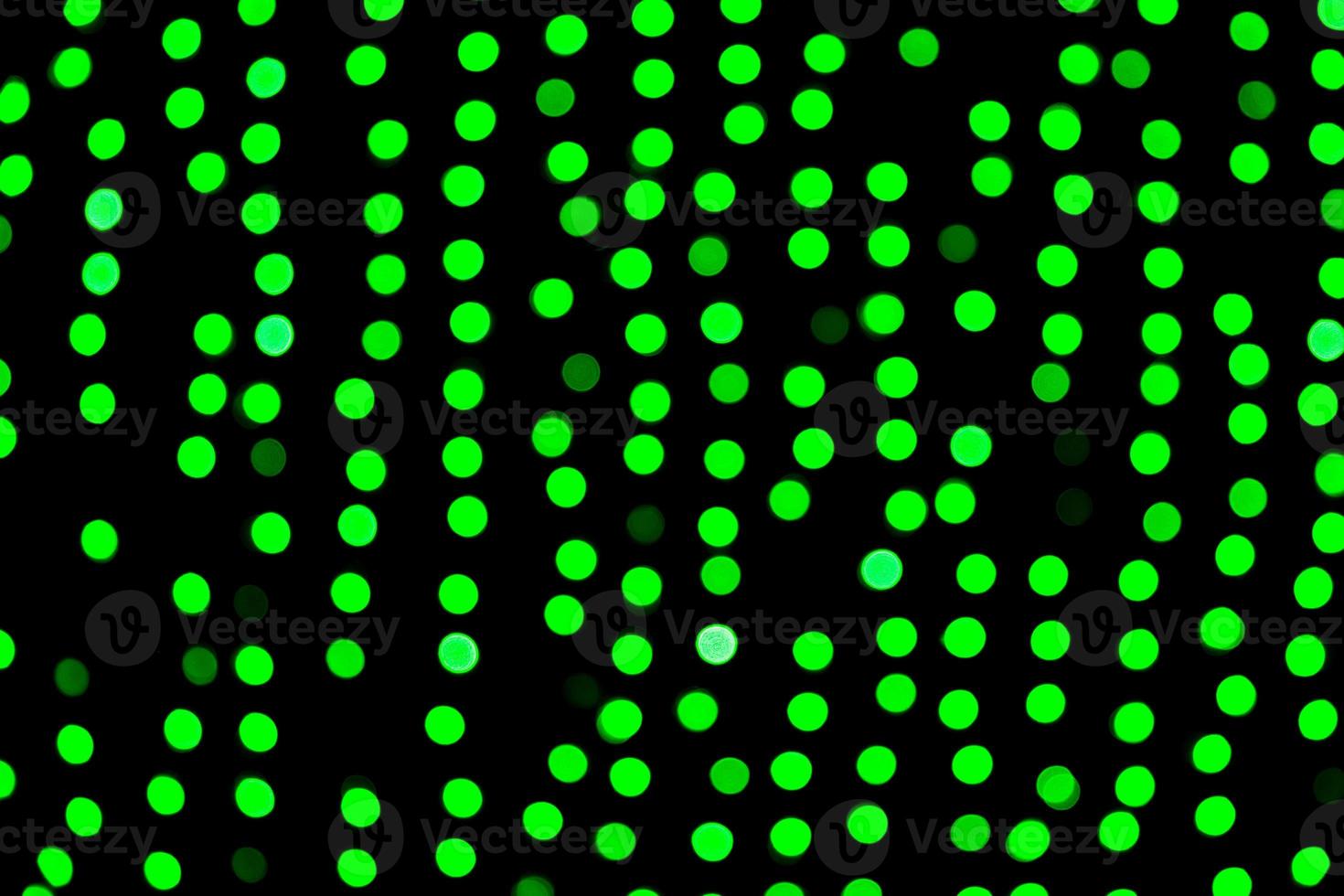 Unfokussiertes abstraktes grünes Bokeh auf schwarzem Hintergrund. defokussiert und verschwommen viele runde licht foto