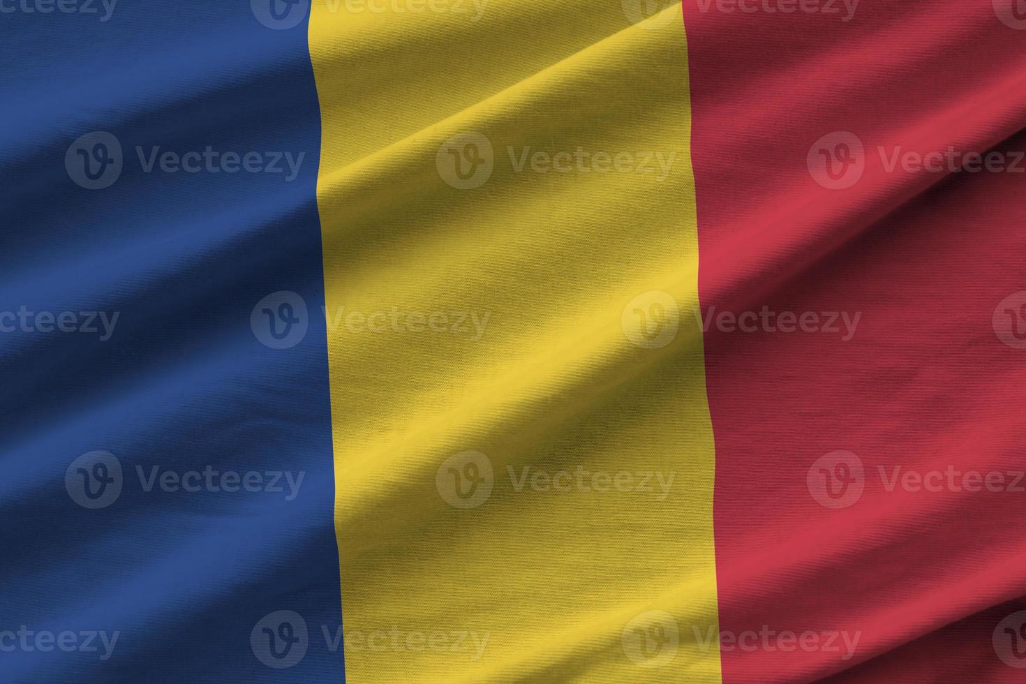 rumänische flagge mit großen falten, die in der nähe unter dem studiolicht im innenbereich wehen. die offiziellen symbole und farben im banner foto