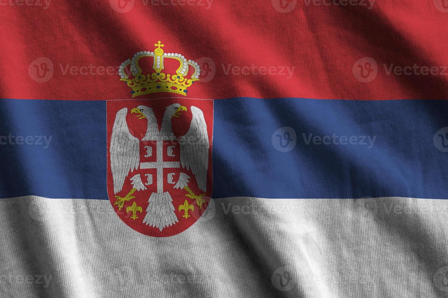 serbien flagge mit großen falten, die dicht unter dem studiolicht im innenbereich wehen. die offiziellen symbole und farben im banner foto