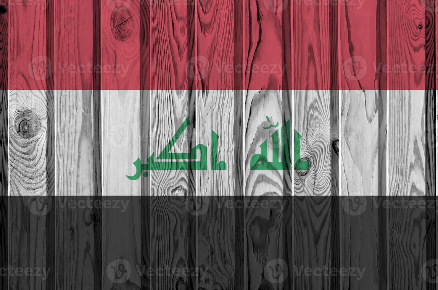 irak-flagge in hellen farben auf alter holzwand dargestellt. strukturierte Fahne auf rauem Hintergrund foto