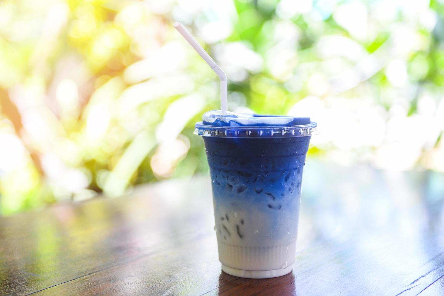 Schmetterlingserbsensaft oder blauer Erbsenblütenkräutertee mit Milch zum Trinken auf Holzhintergrund foto