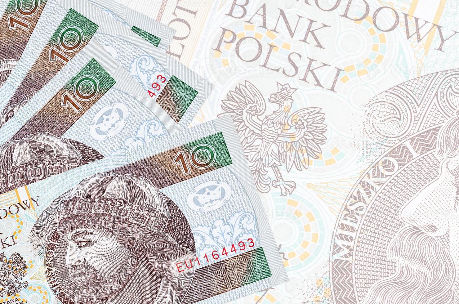 10 polnische Zloty-Scheine liegen im Stapel auf dem Hintergrund einer großen halbtransparenten Banknote. abstrakter betriebswirtschaftlicher hintergrund foto