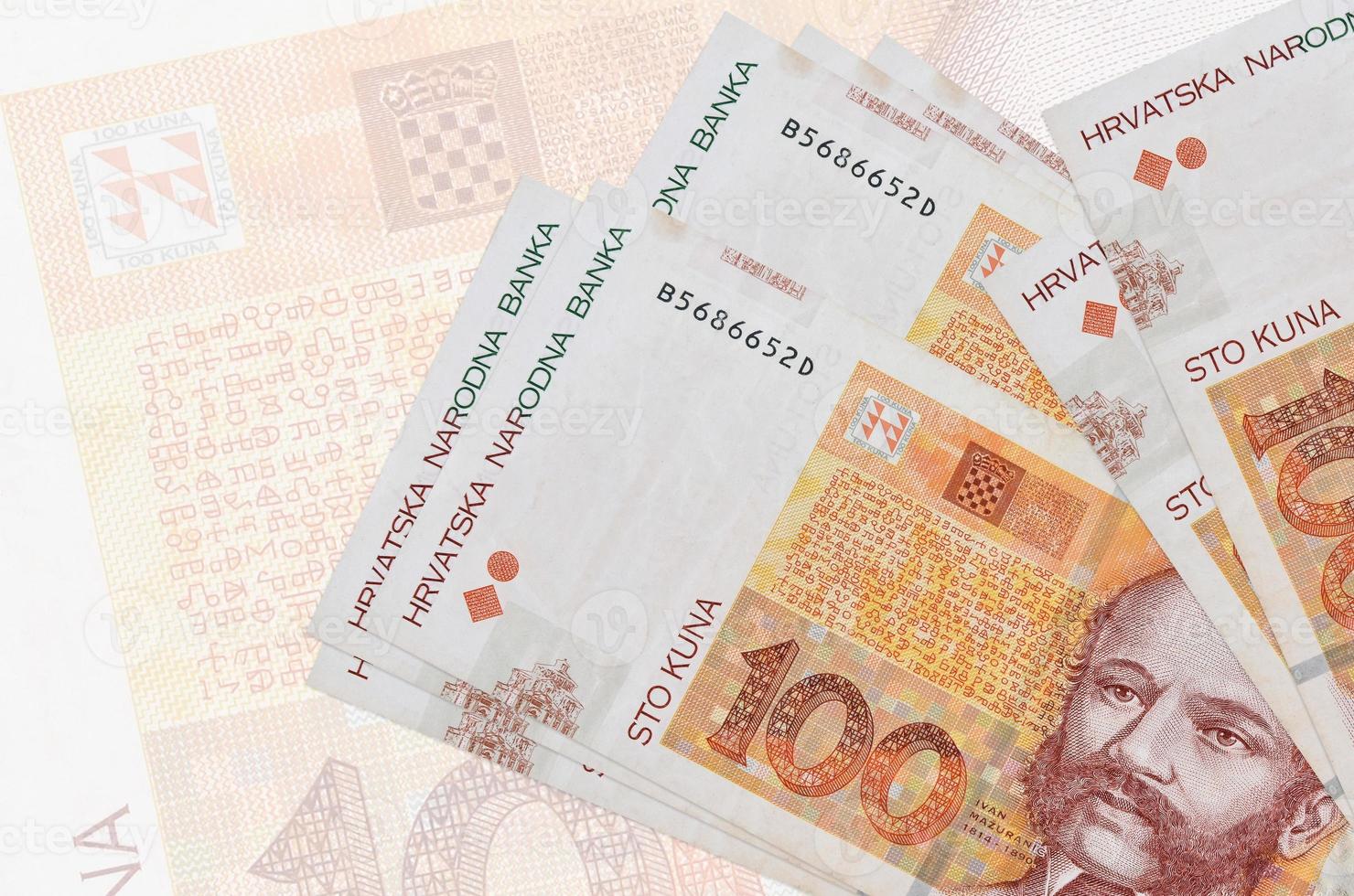 100 kroatische Kuna-Scheine liegen im Stapel auf dem Hintergrund einer großen halbtransparenten Banknote. abstrakte Darstellung der Landeswährung foto