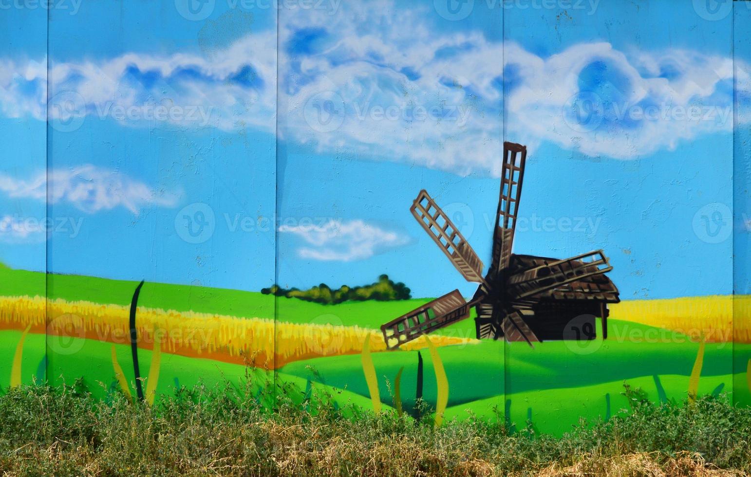 die alte Mauer, gemalt in Graffiti-Farbzeichnung mit Aerosolfarben. ein bild einer traditionellen ukrainischen landschaft mit sonnenblumen, kalina und einer mühle auf einem feld foto