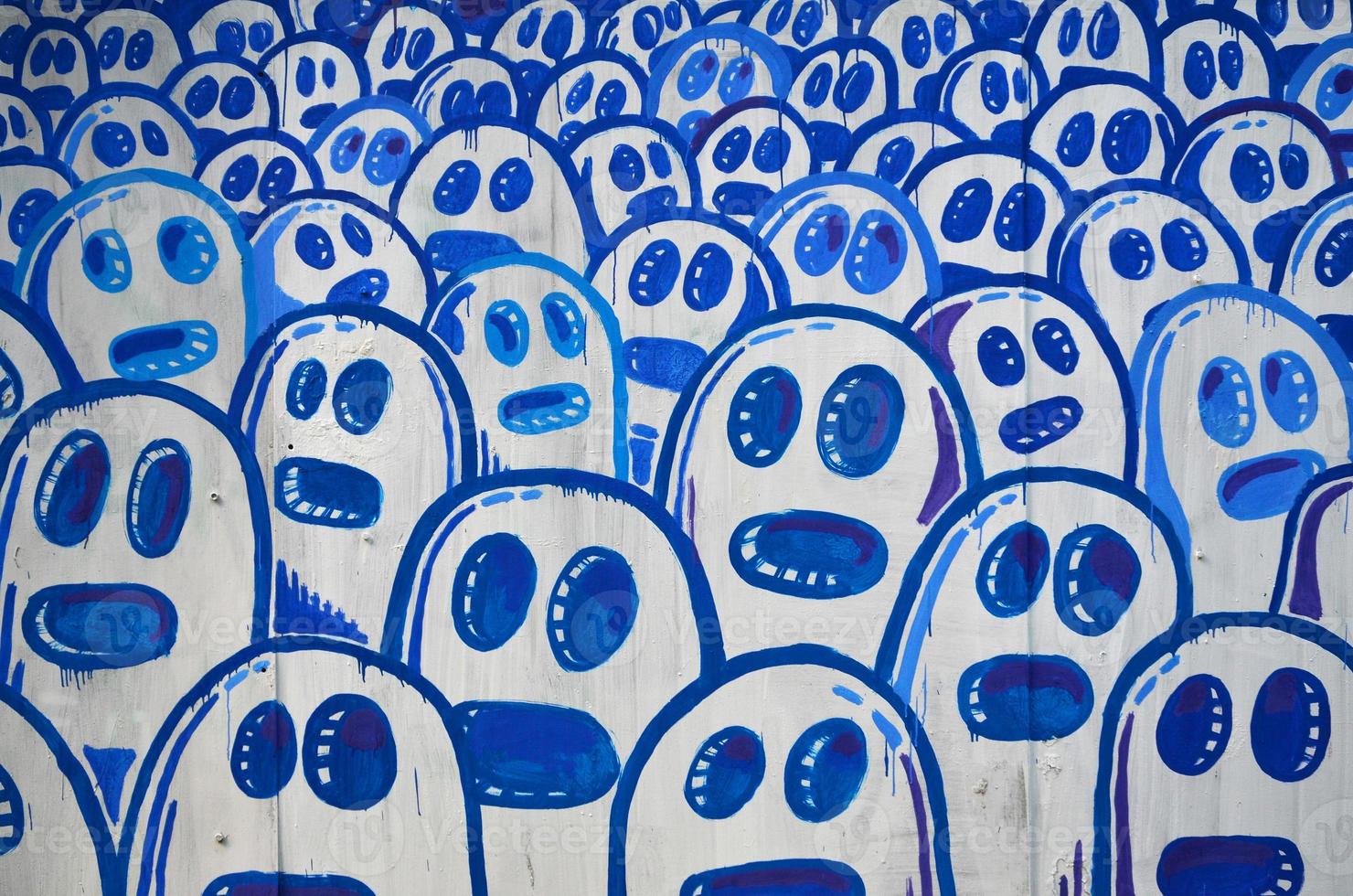 die alte Mauer, gemalt in Graffiti-Farbzeichnung mit Aerosolfarben. das Bild einer Reihe identischer Cartoon-Gesichter. das Konzept einer geistlosen Masse foto