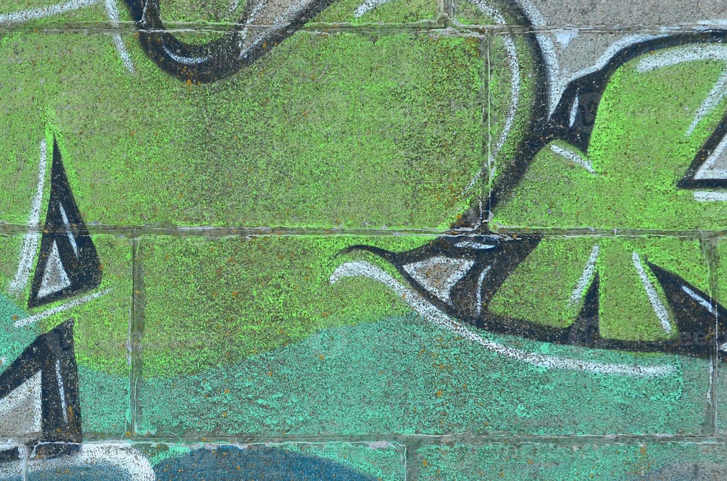 Fragment von Graffiti-Zeichnungen. Die alte Wand ist mit Farbflecken im Stil der Straßenkunstkultur dekoriert. farbige Hintergrundtextur in Grüntönen foto