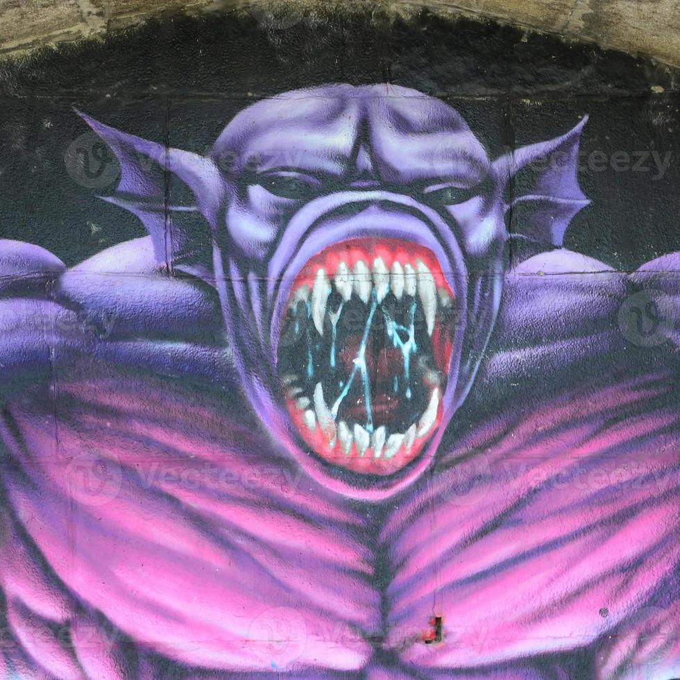 Fragment von Graffiti-Zeichnungen. Die alte Wand ist mit Farbflecken im Stil der Straßenkunstkultur dekoriert. Lila gruseliges Monster foto