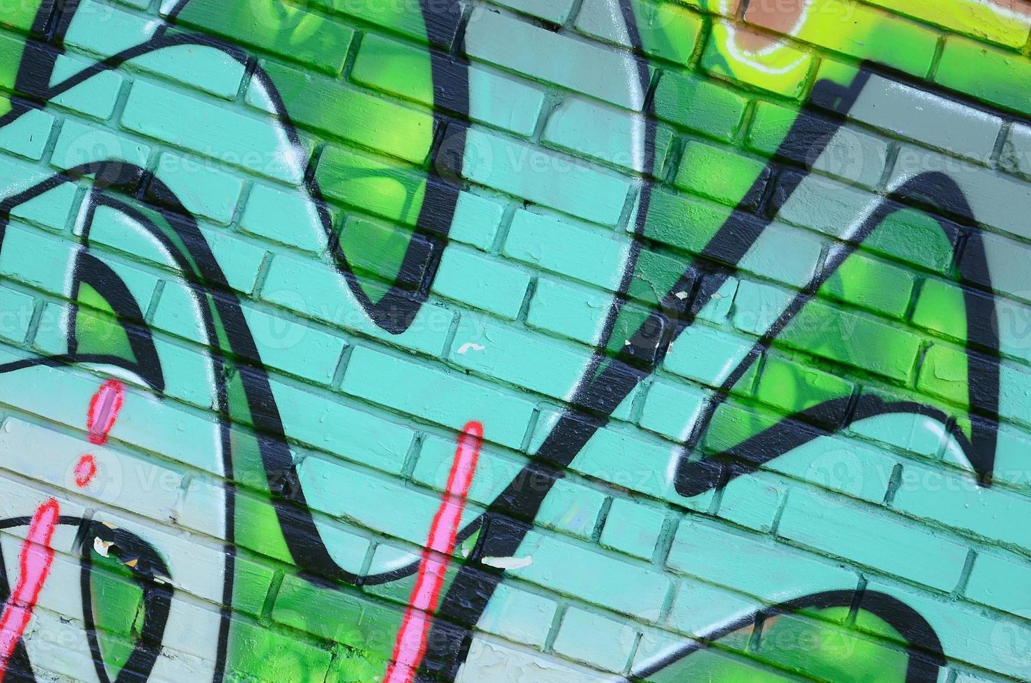 Fragment von Graffiti-Zeichnungen. Die alte Wand ist mit Farbflecken im Stil der Straßenkunstkultur dekoriert. farbige Hintergrundtextur in Grüntönen foto