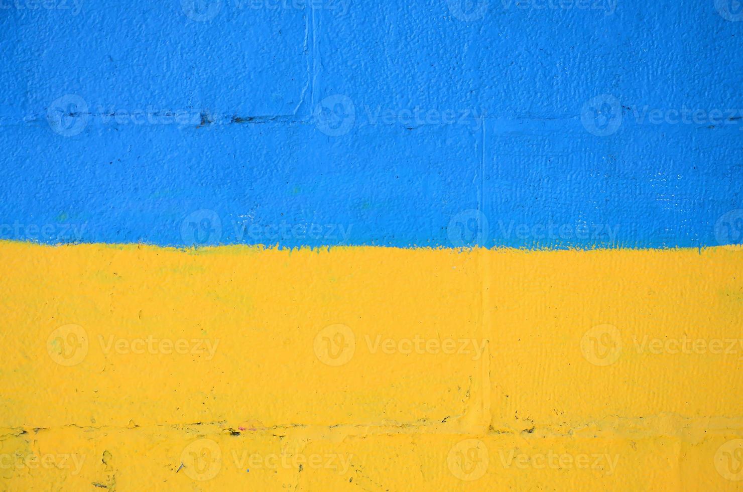 Fragment von Graffiti-Zeichnungen. Die alte Wand ist mit Farbflecken im Stil der Straßenkunstkultur dekoriert. ukrainische Flagge foto