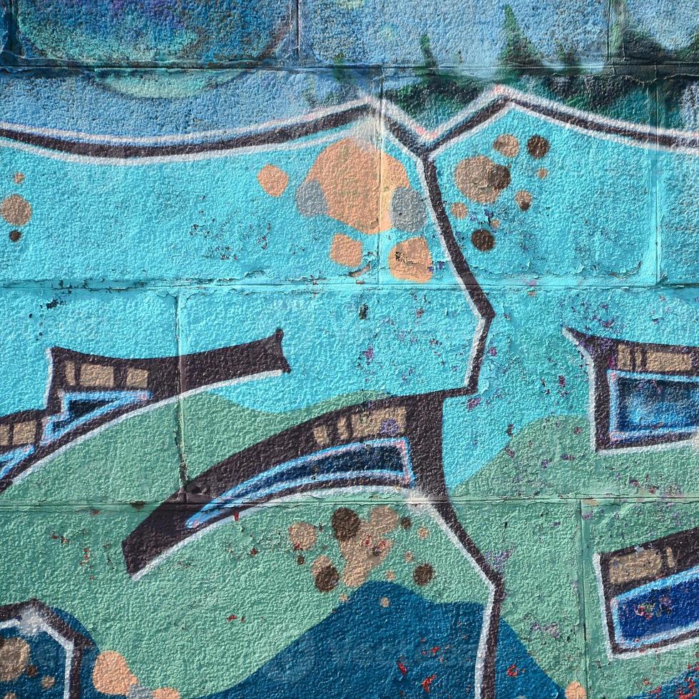 Fragment von Graffiti-Zeichnungen. Die alte Wand ist mit Farbflecken im Stil der Straßenkunstkultur dekoriert. farbige Hintergrundtextur in kalten Tönen foto