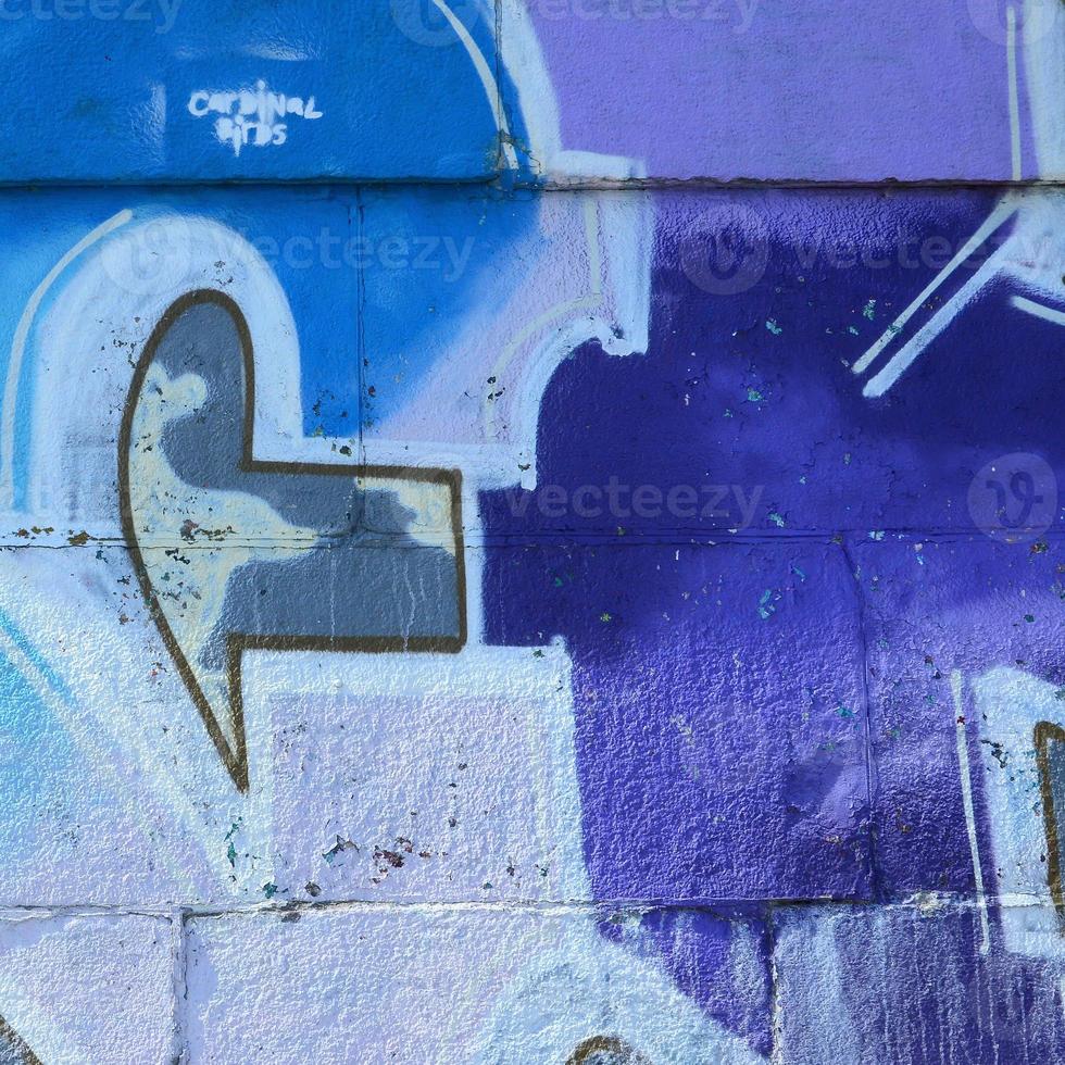 Fragment von Graffiti-Zeichnungen. Die alte Wand ist mit Farbflecken im Stil der Straßenkunstkultur dekoriert. farbige Hintergrundtextur in violetten Tönen foto