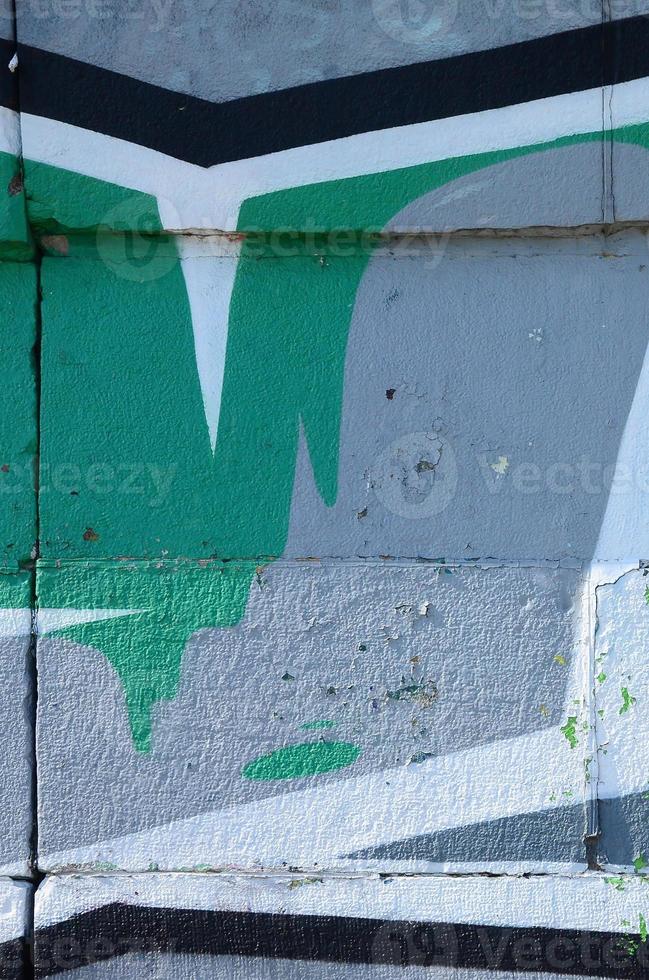 Fragment von Graffiti-Zeichnungen. Die alte Wand ist mit Farbflecken im Stil der Straßenkunstkultur dekoriert. farbige Hintergrundtextur in Grüntönen foto