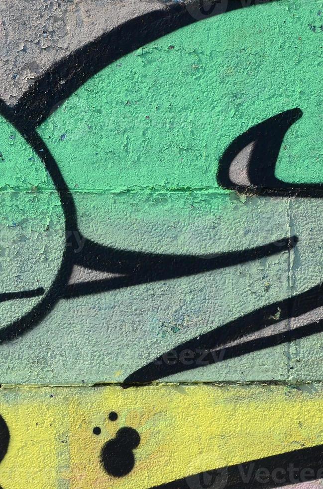 Fragment von Graffiti-Zeichnungen. Die alte Wand ist mit Farbflecken im Stil der Straßenkunstkultur dekoriert. farbige Hintergrundtextur in Grüntönen foto