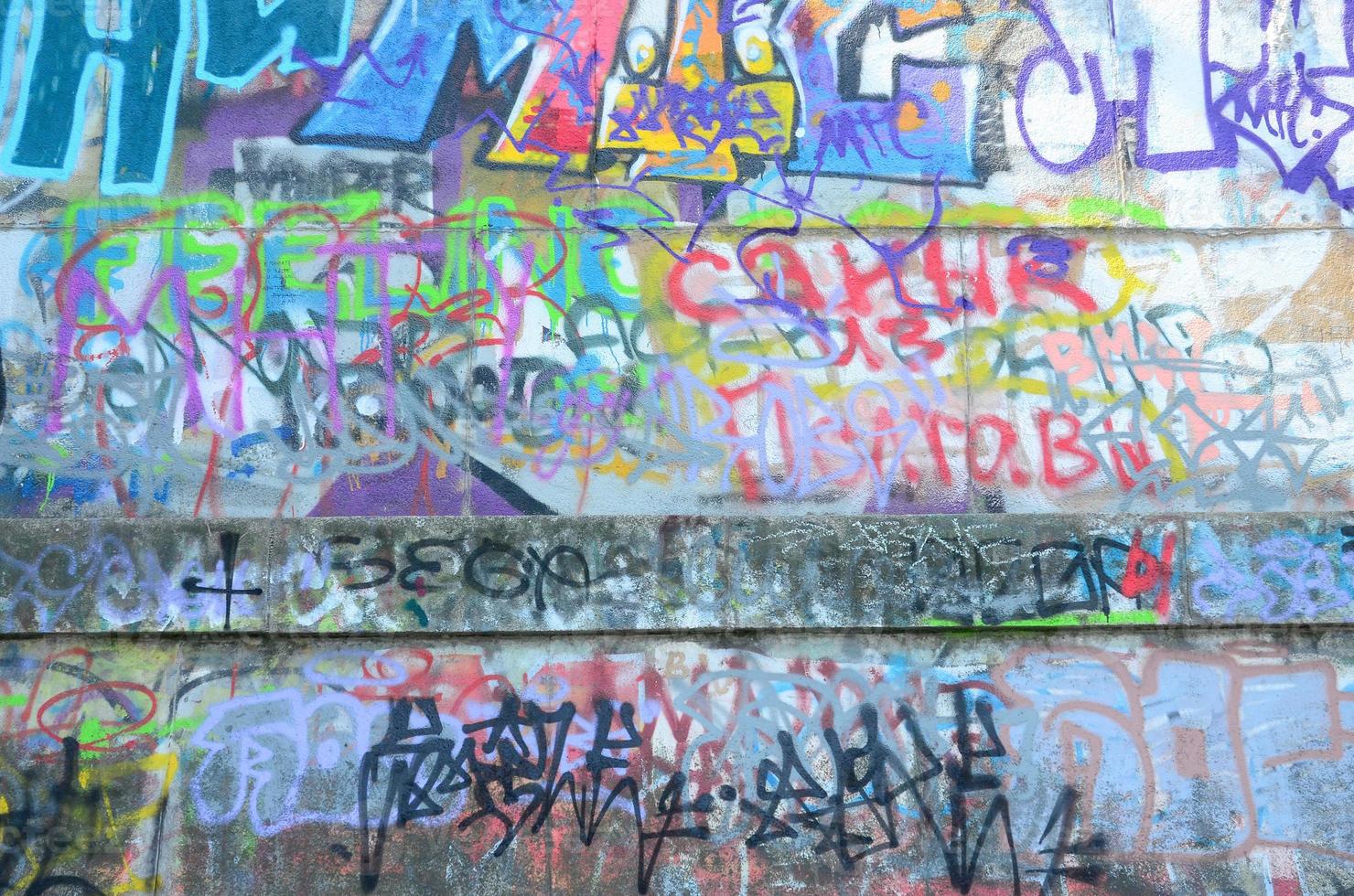 Fragment von Graffiti-Tags. Die alte Mauer ist mit Farbflecken im Stil der Street-Art-Kultur verwöhnt foto