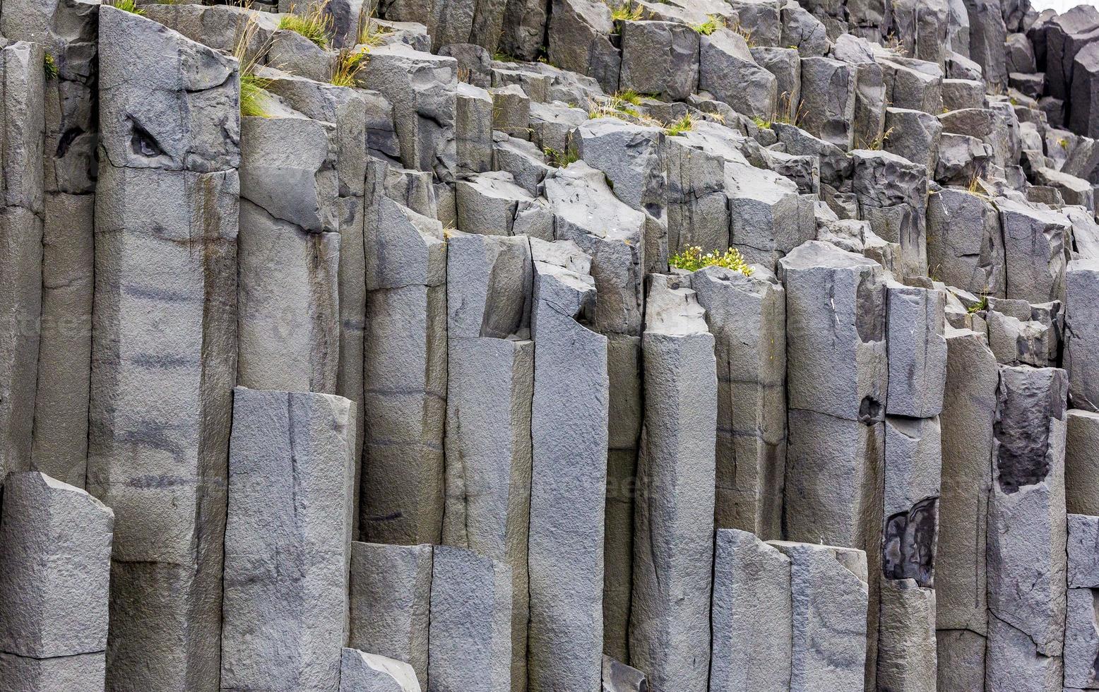 blick auf den schwarzen reynisfjara-strand mit beeindruckenden basaltsäulen in südisland tagsüber foto