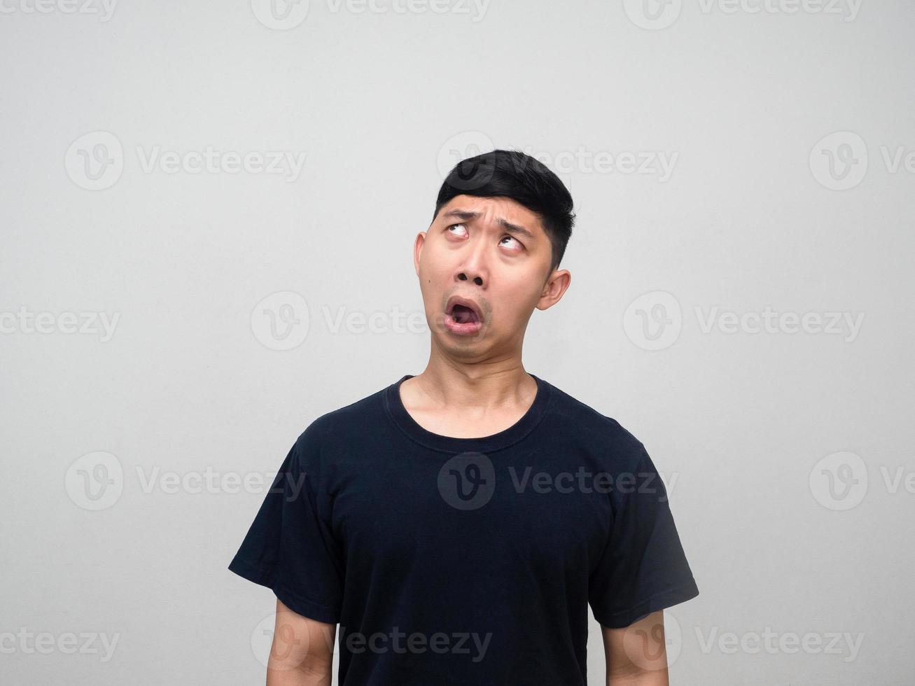 junger asiatischer mann fühlt sich verwirrt und schaut isoliert nach oben foto