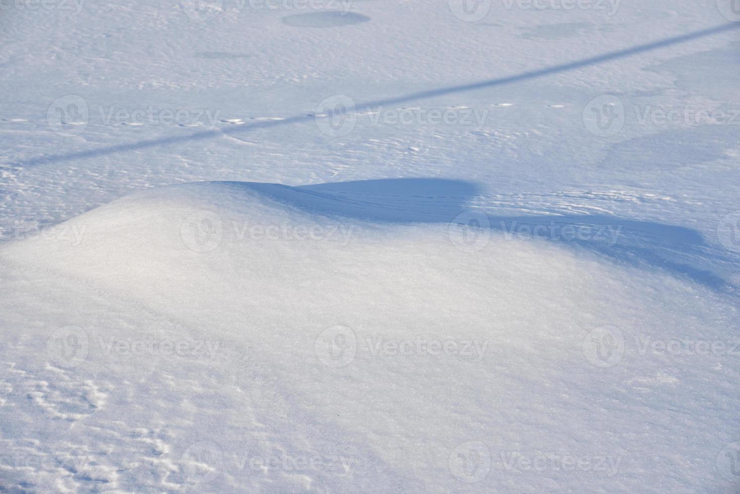 schneebedeckte Oberfläche. weißer Schnee und Schneeverwehungen im Winter. foto