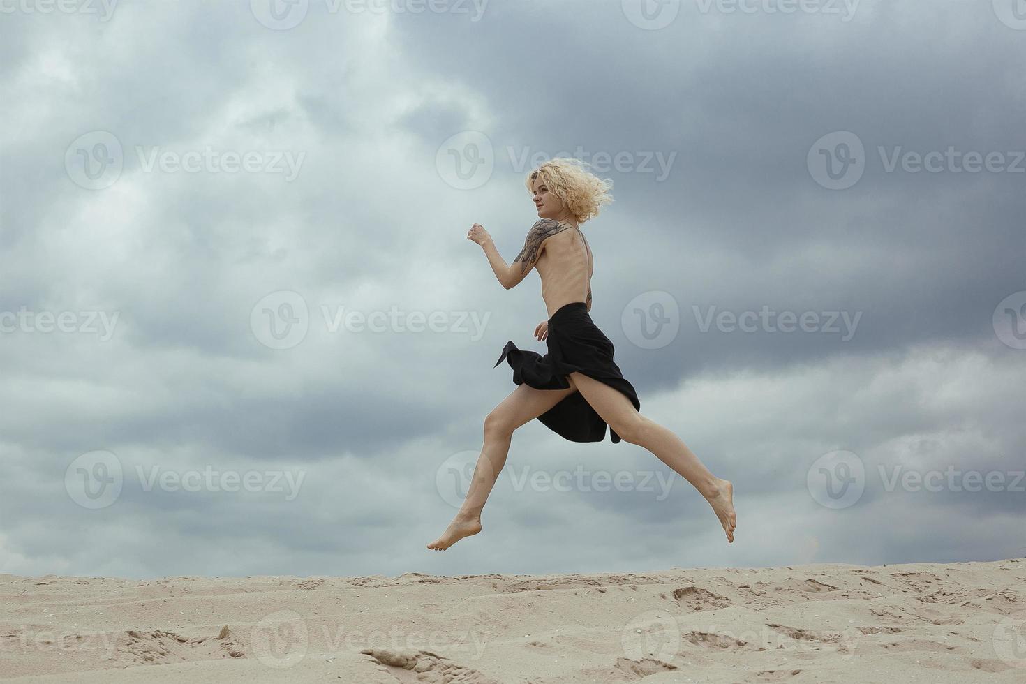 blonde nackte dame, die entlang der szenischen fotografie des strandes läuft foto