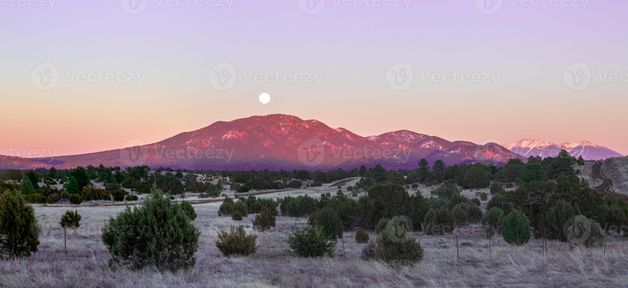 der vollmond geht abends zur winterzeit über dem humphreys peak in der nähe des grand canyon in arizona auf foto