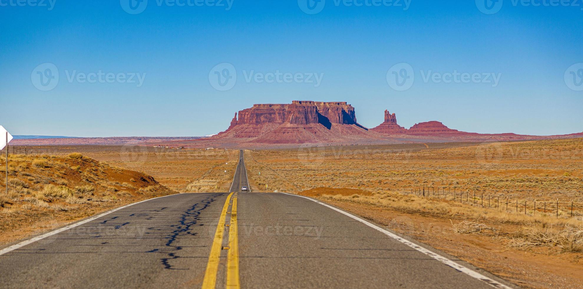 Panoramabild einer endlosen Straße vor einer majestätischen Felsformation im Monument Valley National Park im Winter foto