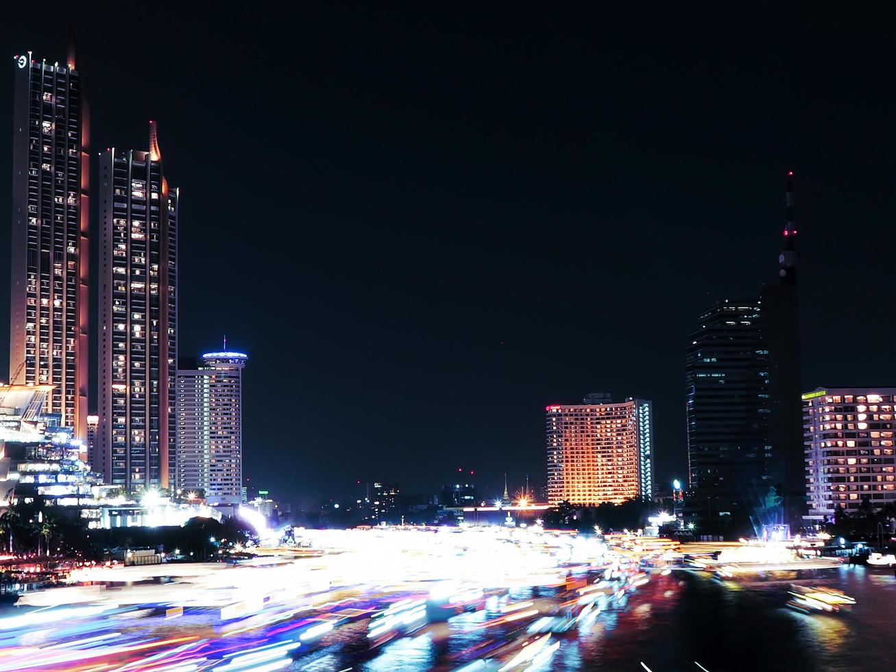 schöne lichter des öffentlichen wasserverkehrs, bootsverkehr auf dem chao phraya fluss mit eigentumswohnungen. Hotels bei Nacht in Bangkok, der Hauptstadt von Thailand foto