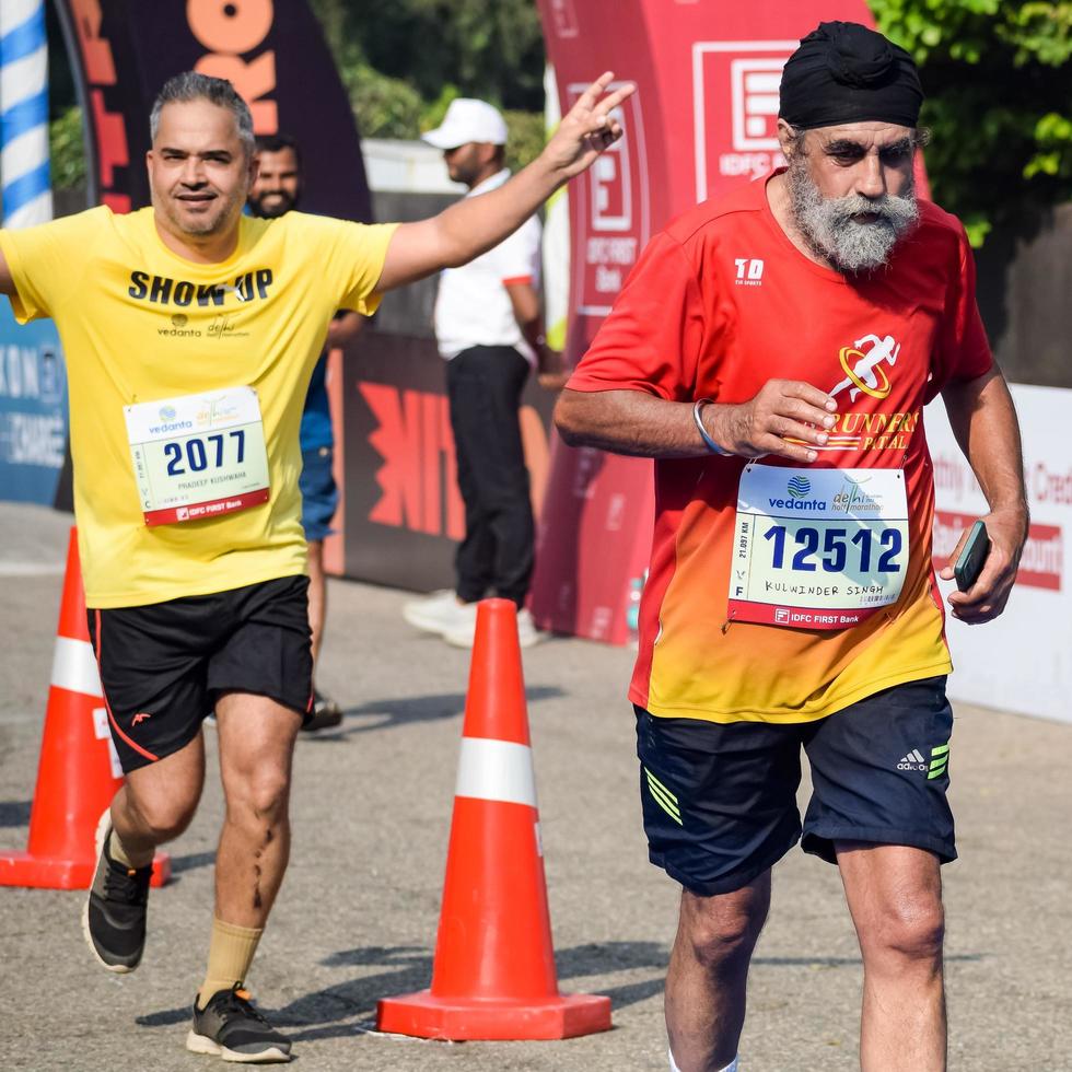 neu delhi, indien - 16. oktober 2022 - vedanta delhi halbmarathonrennen nach covid, bei dem die marathonteilnehmer kurz vor dem überqueren der ziellinie stehen, delhi halbmarathon 2022 foto