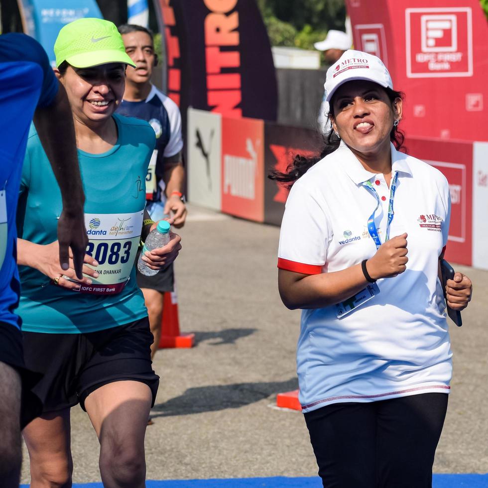 neu delhi, indien - 16. oktober 2022 - vedanta delhi halbmarathonrennen nach covid, bei dem die marathonteilnehmer kurz vor dem überqueren der ziellinie stehen, delhi halbmarathon 2022 foto