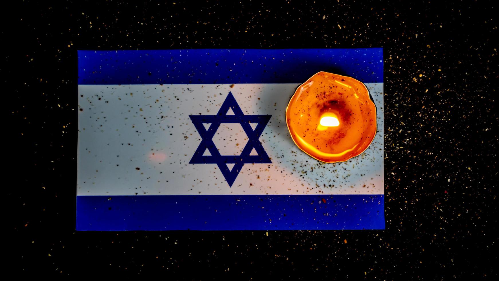 israelische flagge und kerzen, die darüber brennen, holocaust-gedächtnistag foto