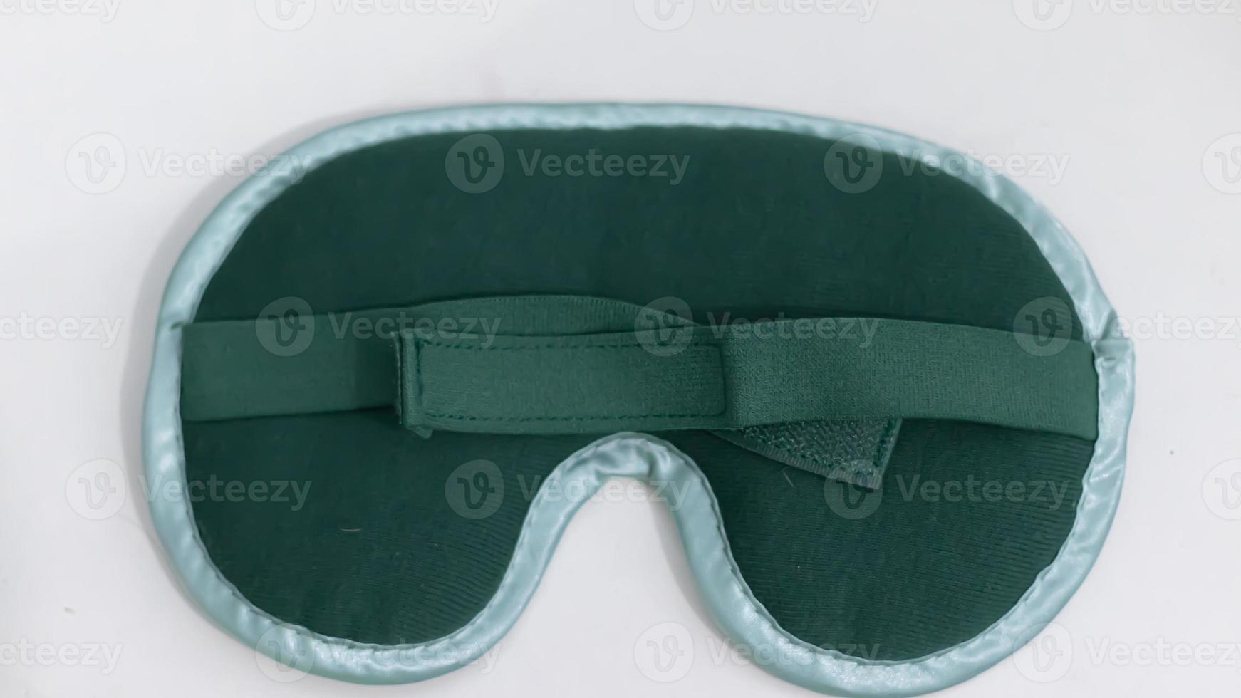 grüne schlafende Augenmaske, isoliert auf weißem Hintergrund foto