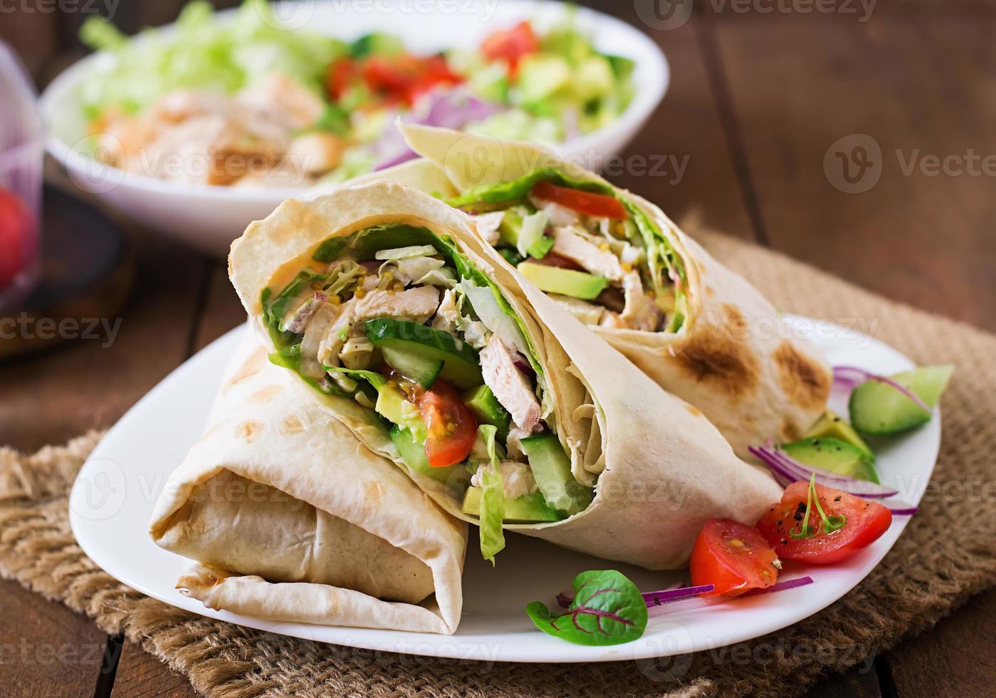 frische Tortilla-Wraps mit Hühnchen und frischem Gemüse auf dem Teller foto