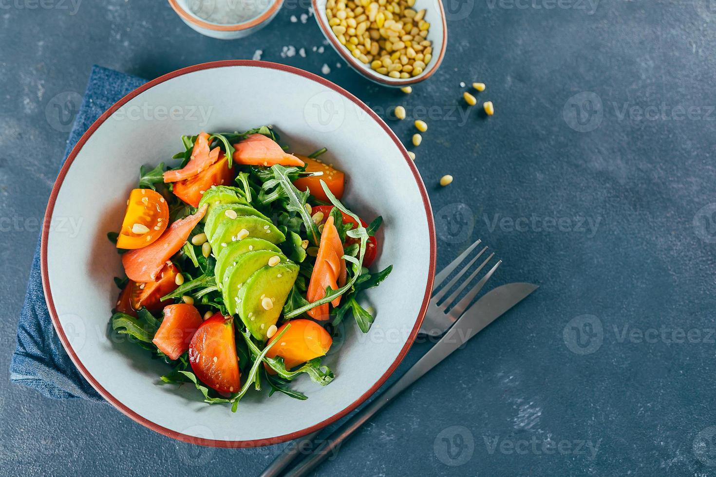 Gesunder veganer Salat mit Avocado, Tomate, Rucola, Lachs. Diät-Menü. Draufsicht, Kopierbereich foto