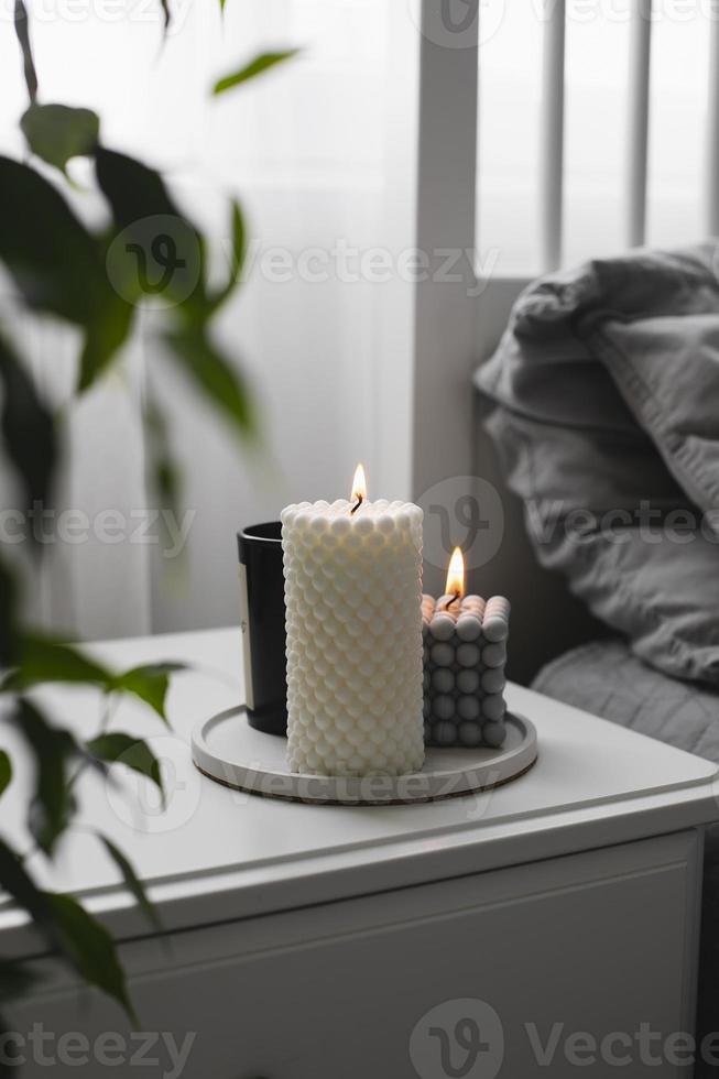 Luxus Aroma brennende Kerze im Schlafzimmer auf dem Nachttisch. Zuhause gemütliches Interieur foto