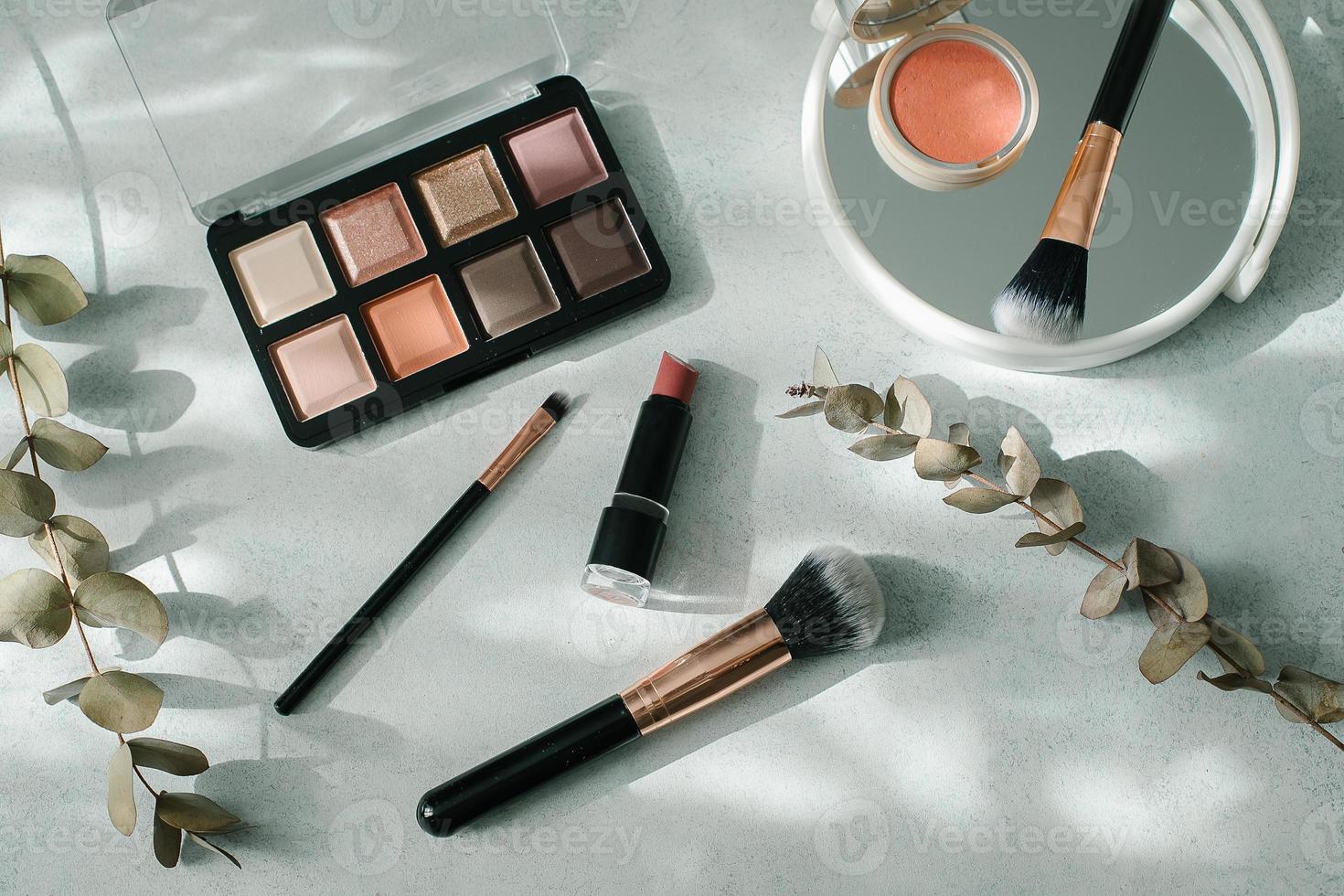 Make-up-Pinsel und Kosmetik auf hellem Hintergrund. Schönheit, Modekonzept. foto