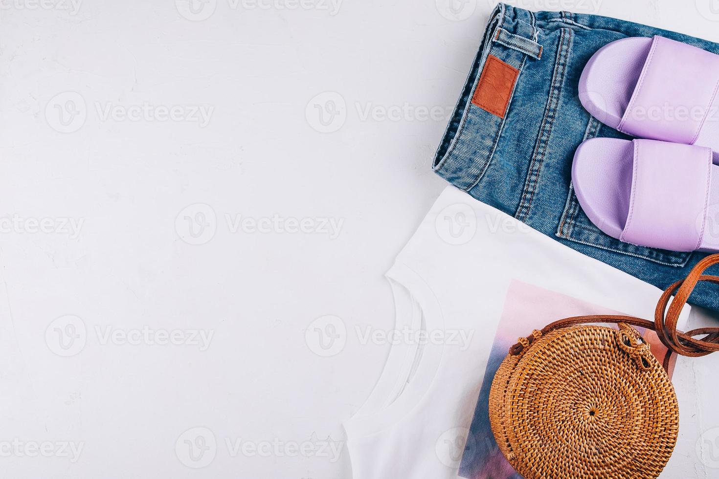 lässiges Damenoutfit, Accessoires. T-Shirt, Sommerpantoffeln, Shorts, Rattantasche. Platz kopieren foto